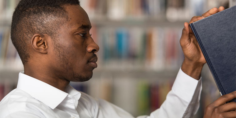 Student removing book from shelf